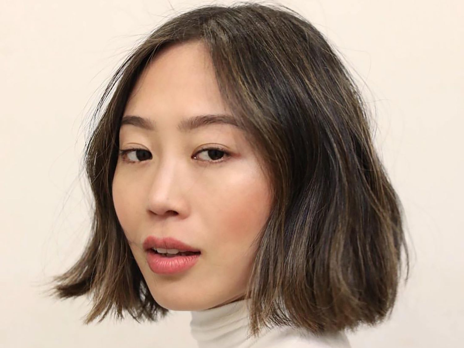 Blogger Aimee Song looks at the camera with a short balyage bob 