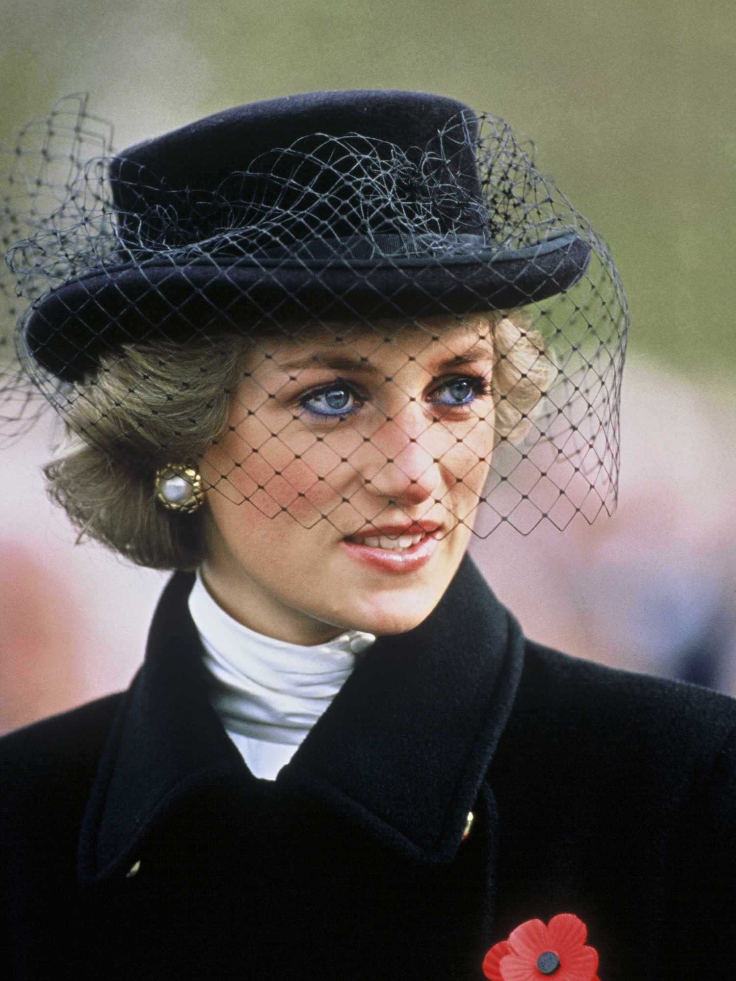 Princess Diana with a short bob hairstyle and black brimmed hat with netting