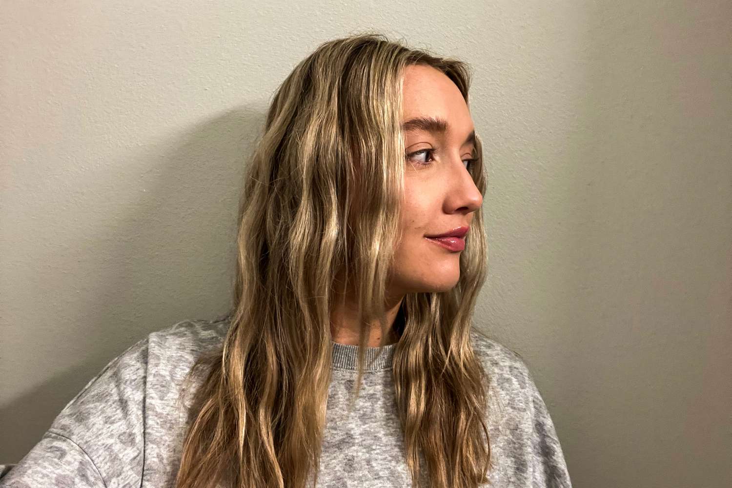 A person facing to the side after spraying their waves with Living Proof Style Lab Flex Hairspray