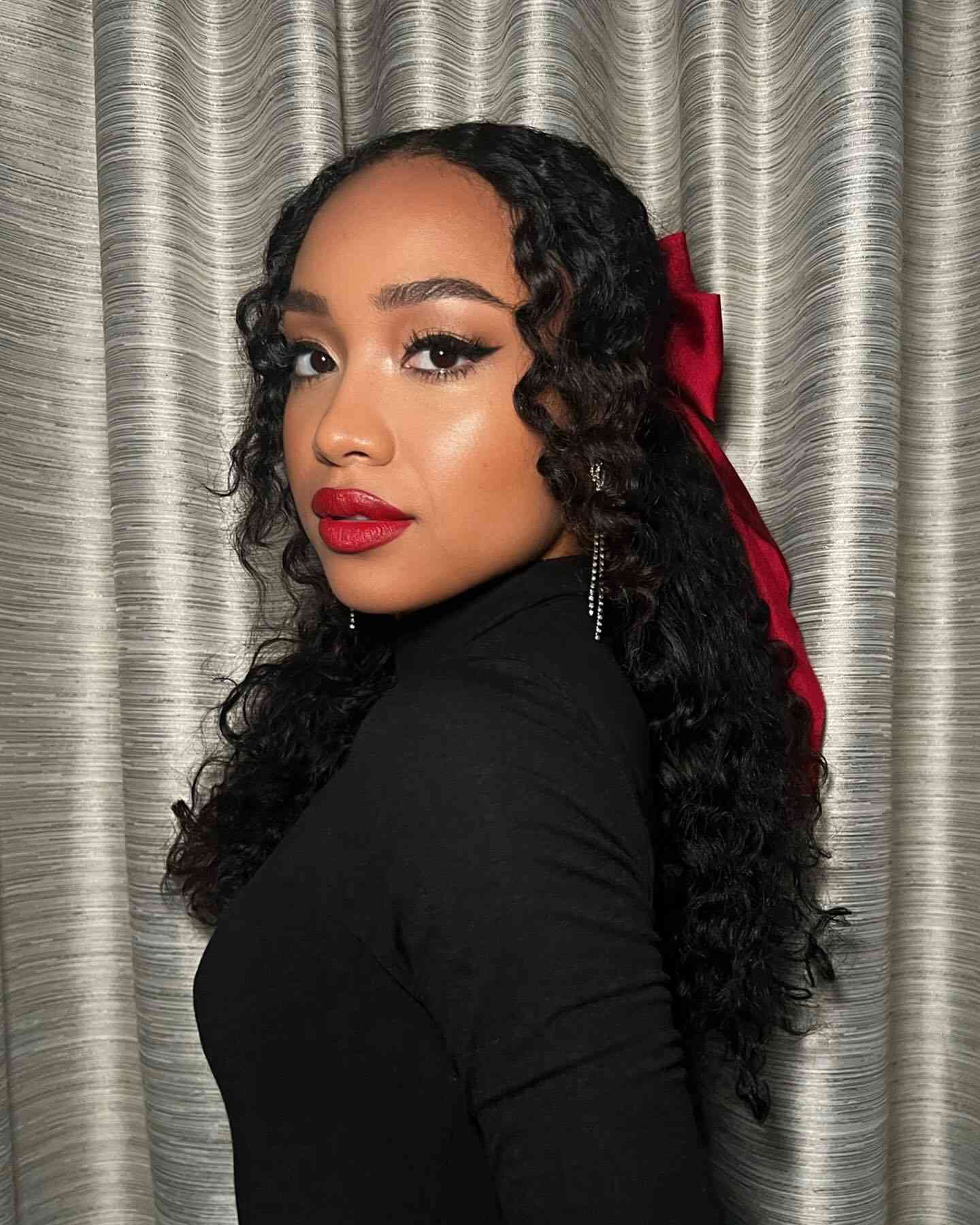 Woman wearing red lipstick and a matching red hairbow