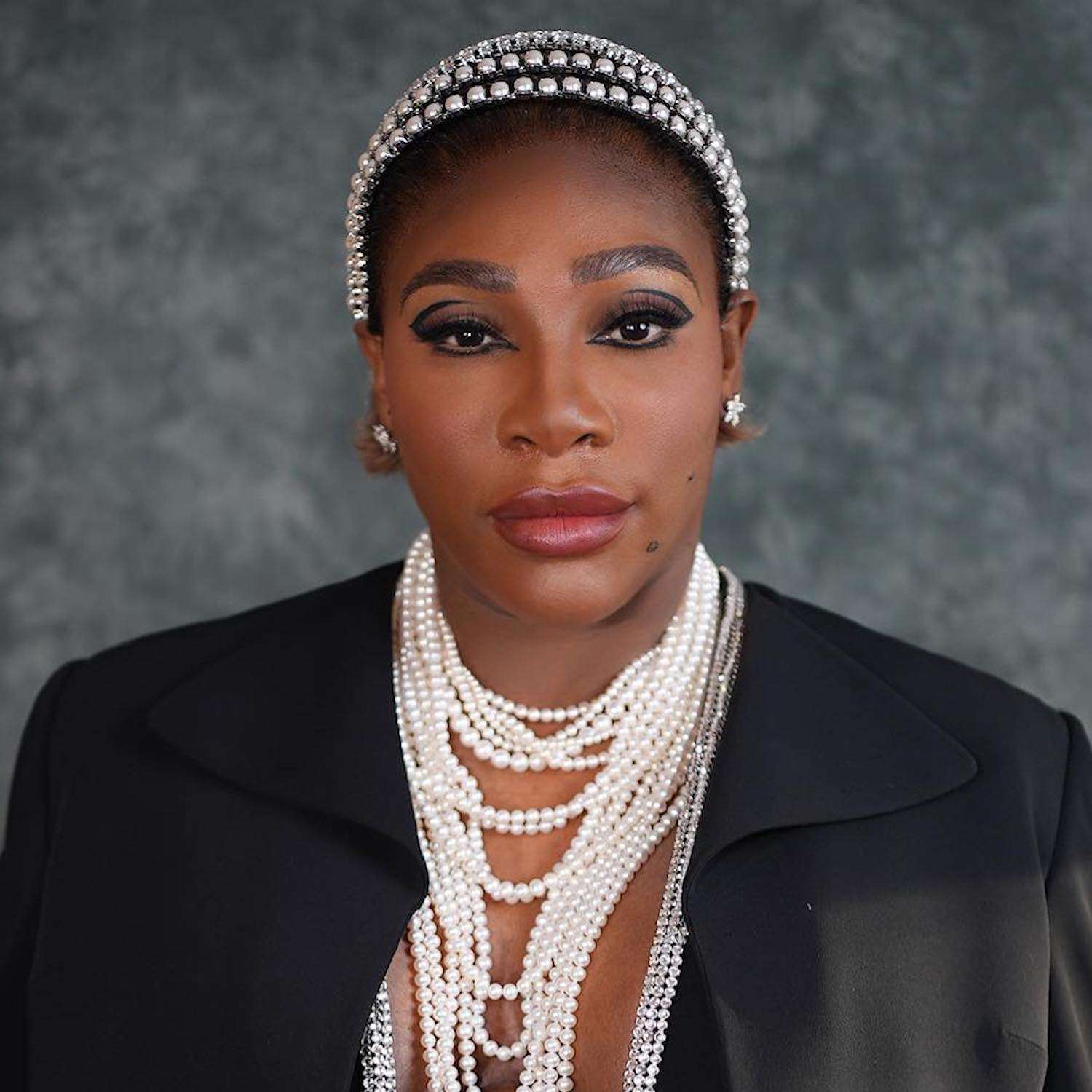 Serena Williams wears a slicked-back ombre bob hairstyle with layered pearl headbands and necklaces