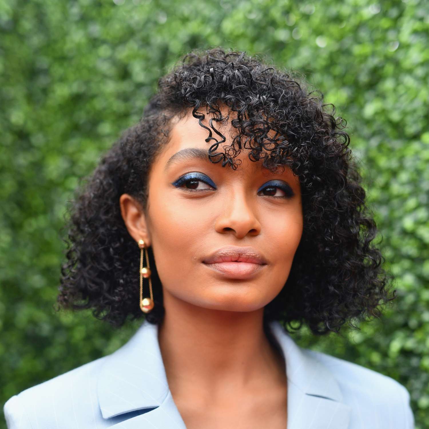 Yara Shahidi with a curly-coily bob haircut with bangs