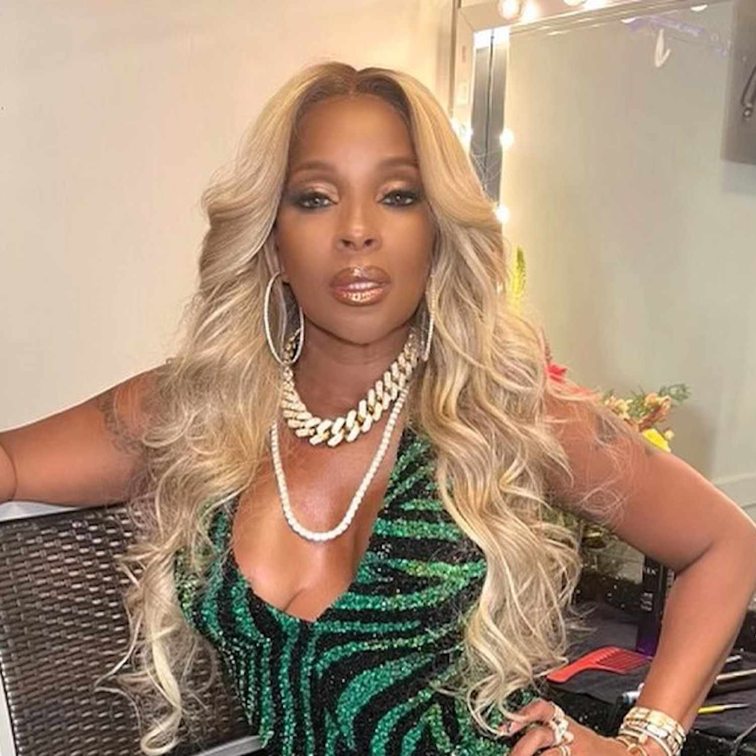 Mary J. Blige wears a bright, beige-toned blonde curled hairstyle