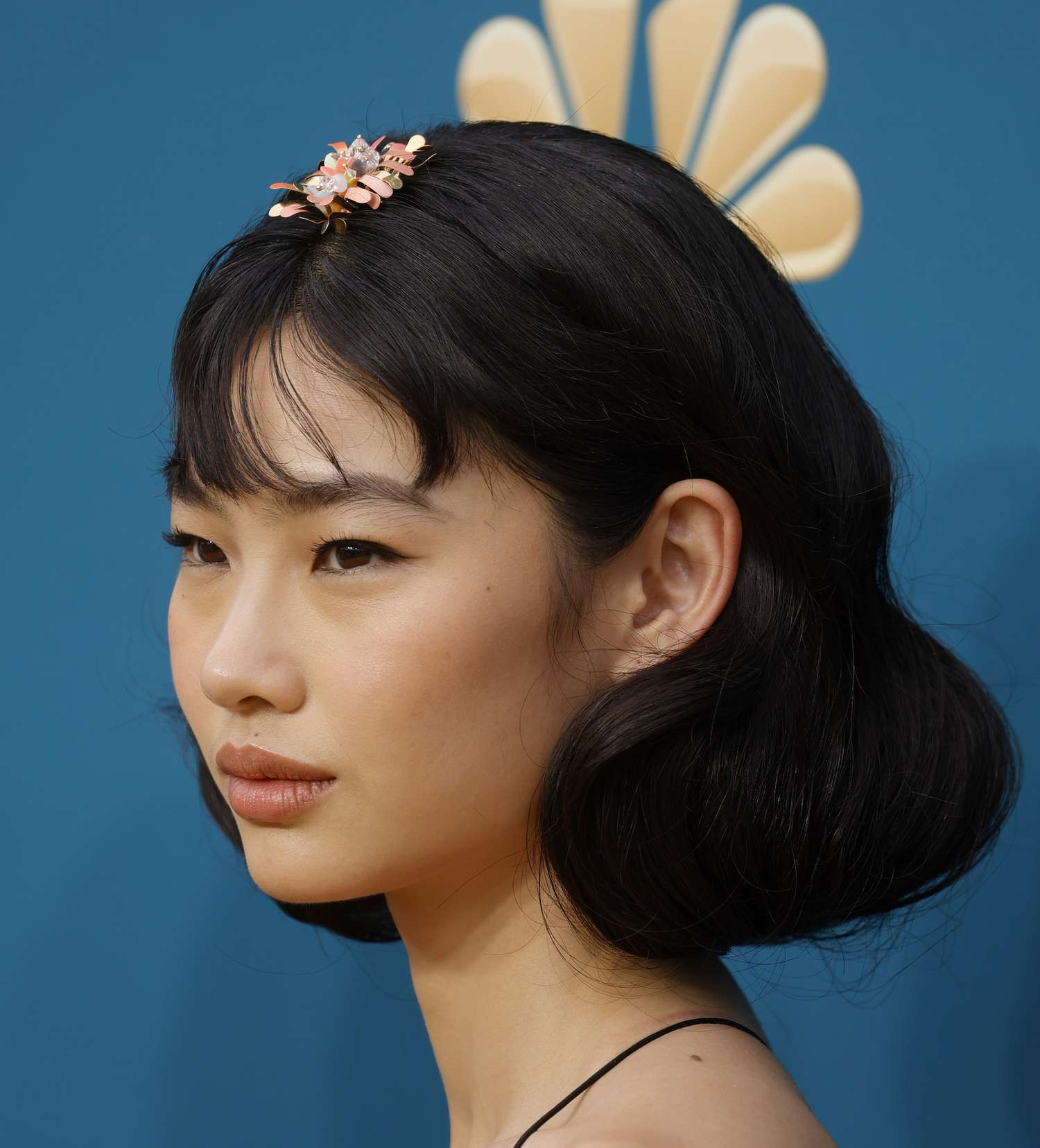 Hoyeon Jung with a voluminous faux bob hairstyle and pink floral applique