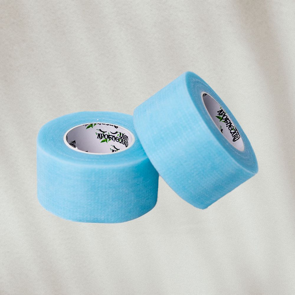 Two rolls of blue eyelash tape on textured background