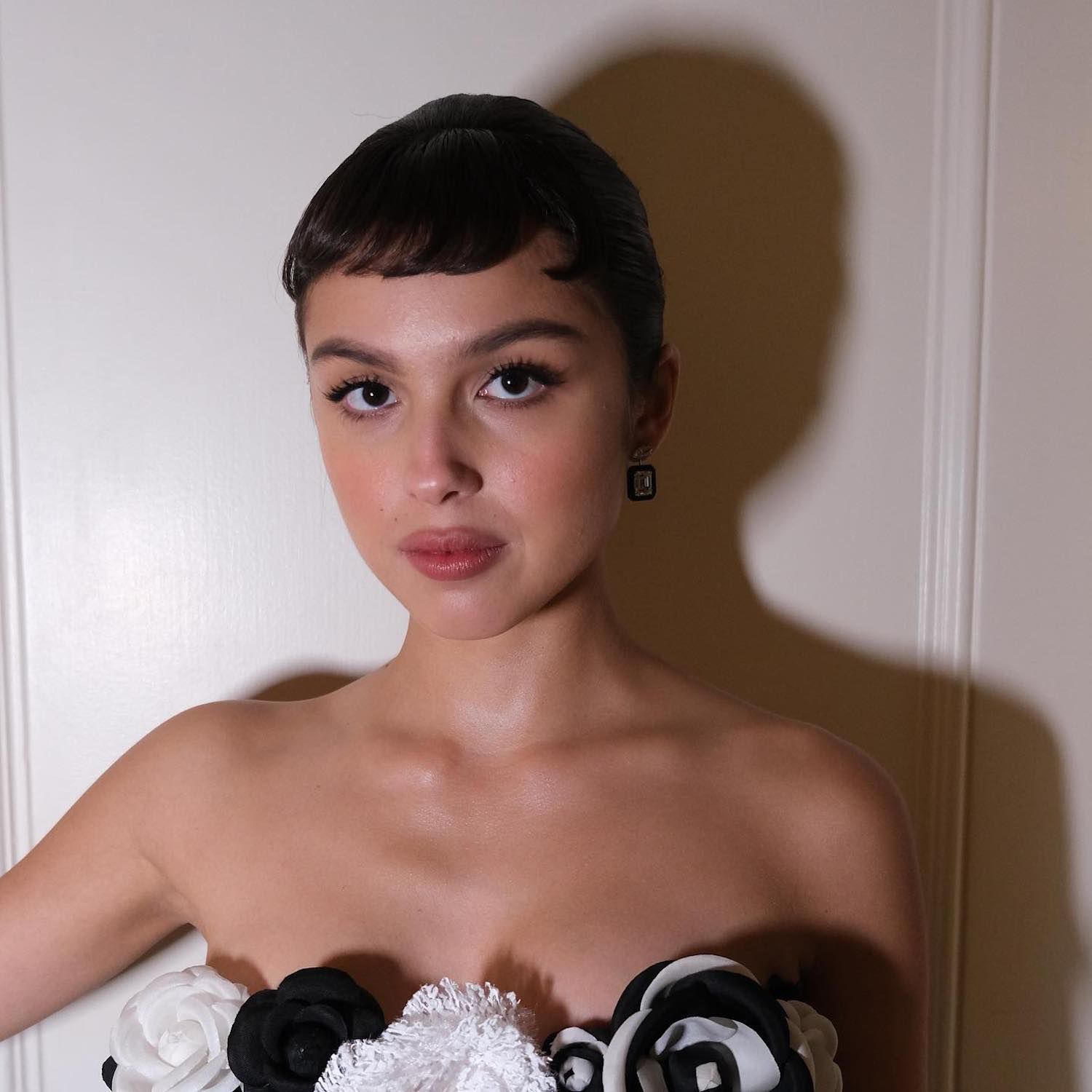 Olivia Rodrigo wears a sleek bun hairstyle with baby bangs to the 2023 Met Gala