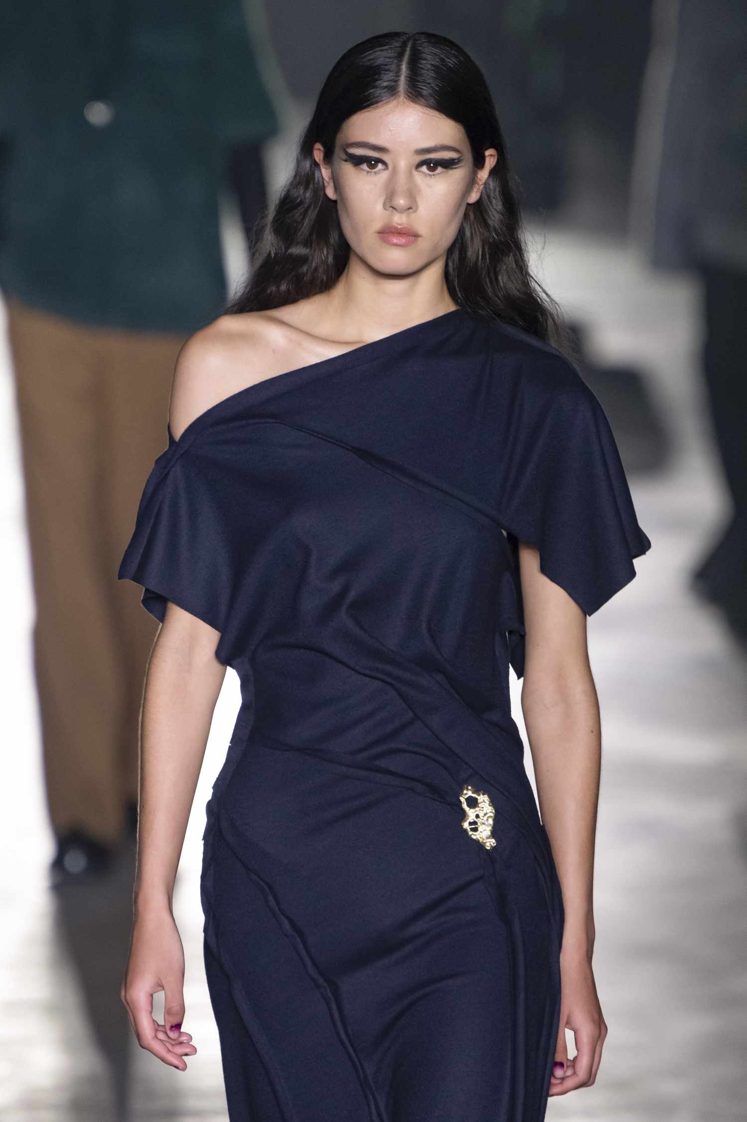 A model walks the Jason Wu runway show wearing a navy blue one shoulder neckline dress. 