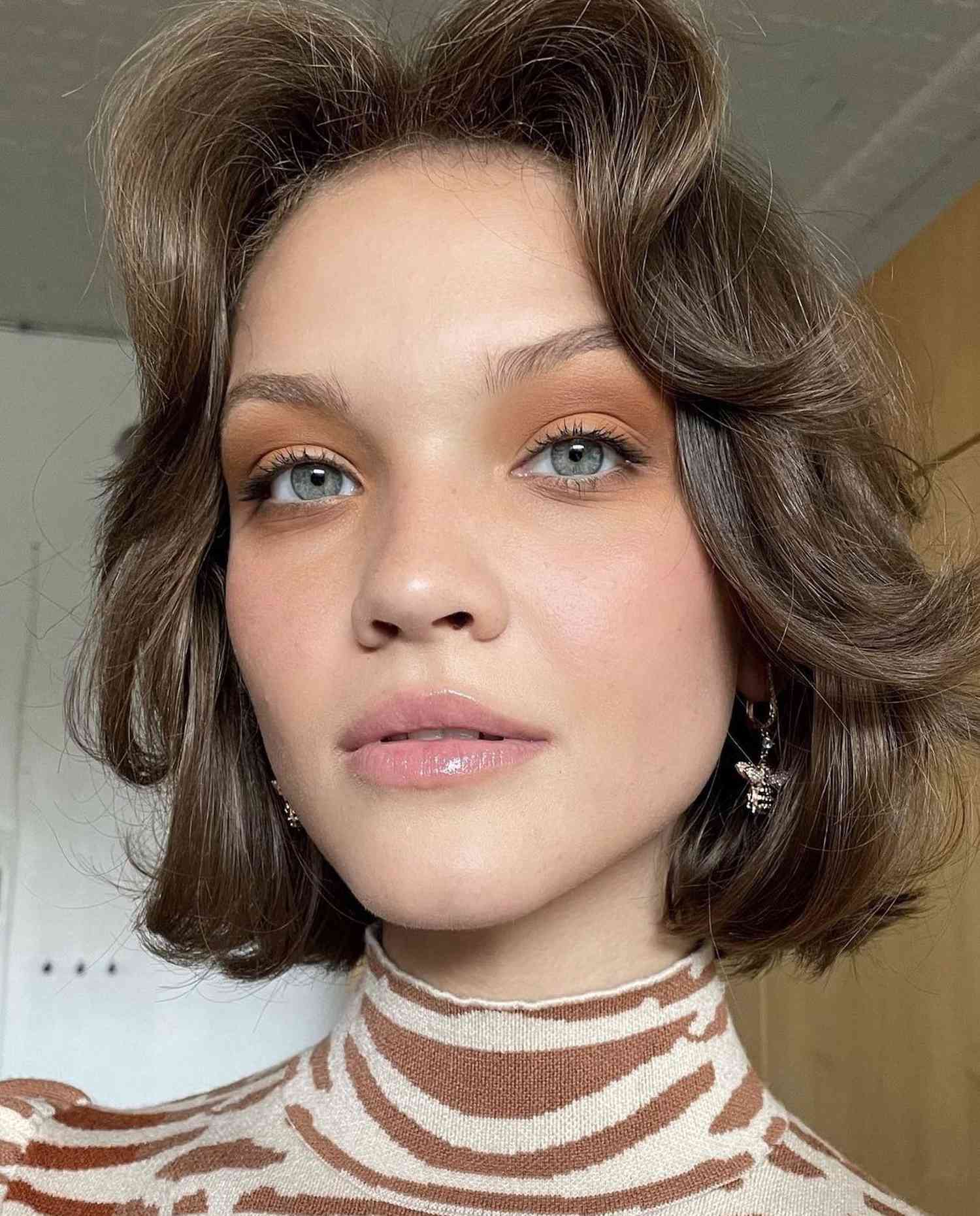 Close up of a model with cinnamon eyeshadow and frosty pink lips