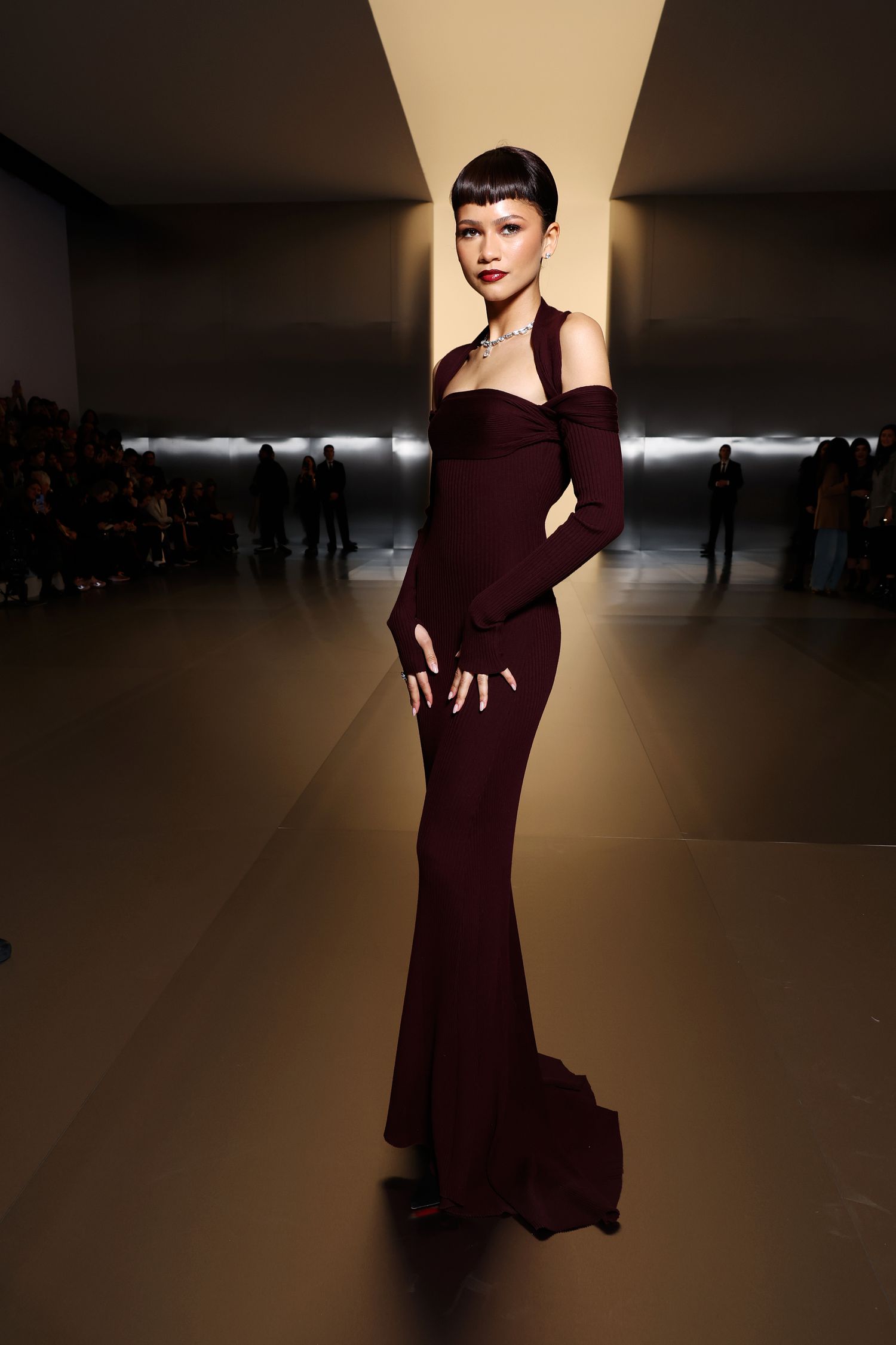 Zendaya at the Feni Haute Couture show with blunt bangs and vampy wine-red makeup and clothes