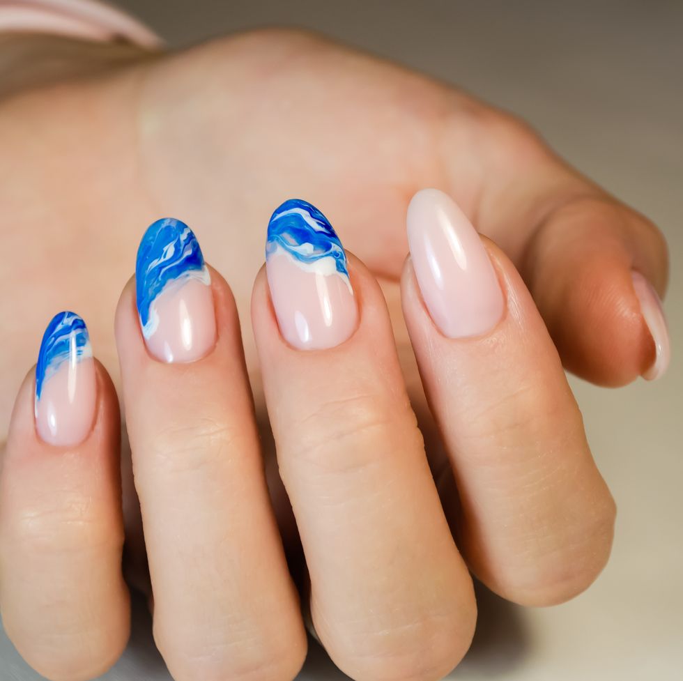 hands of a young woman the nails are covered with a light colored gel polish with a bright design manicure ideas