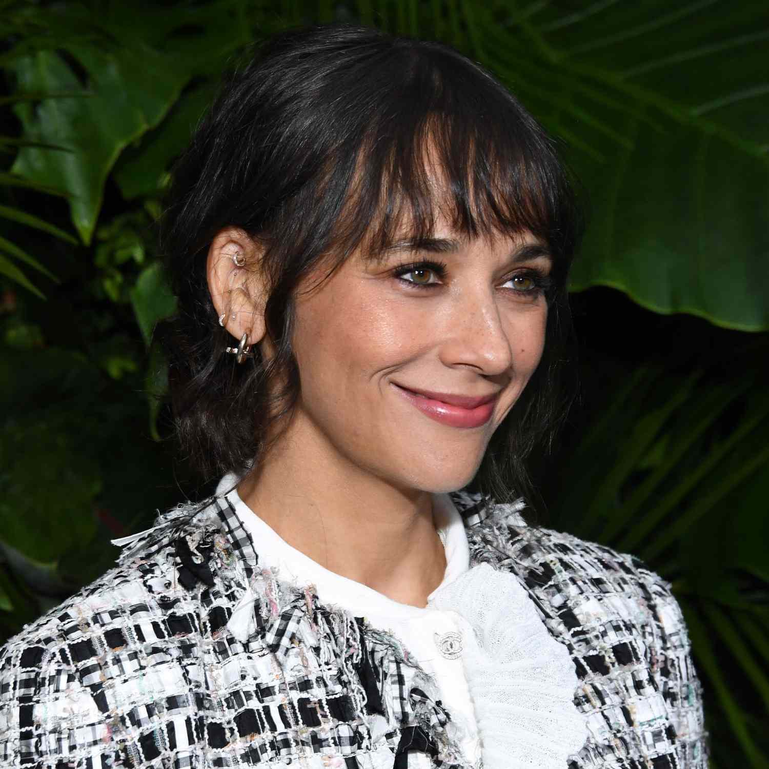 Rashida Jones wears a low updo with blunt bangs on the red carpet