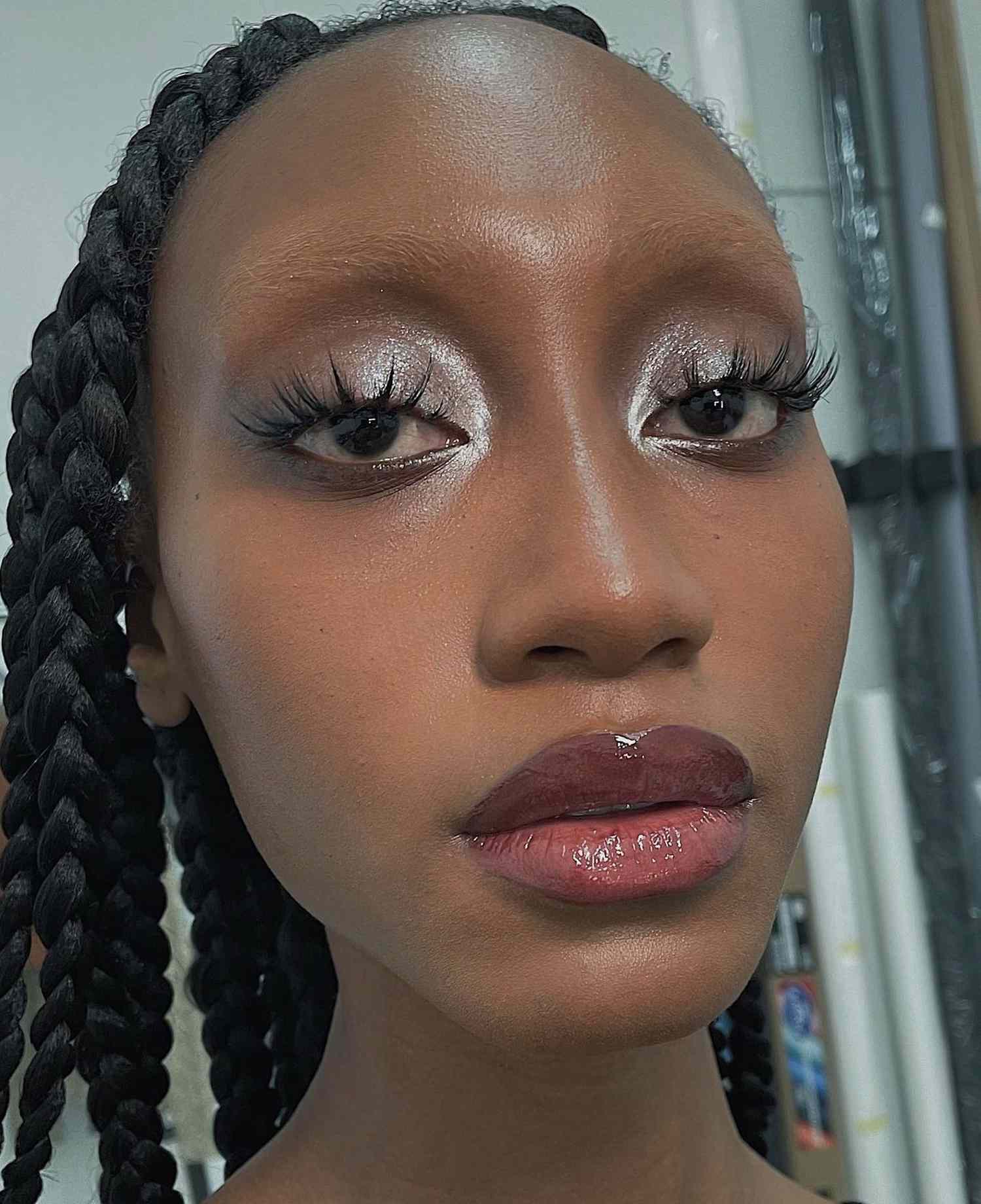 Close up of a model with silvery eyeshadow and cranberry, glossy lips