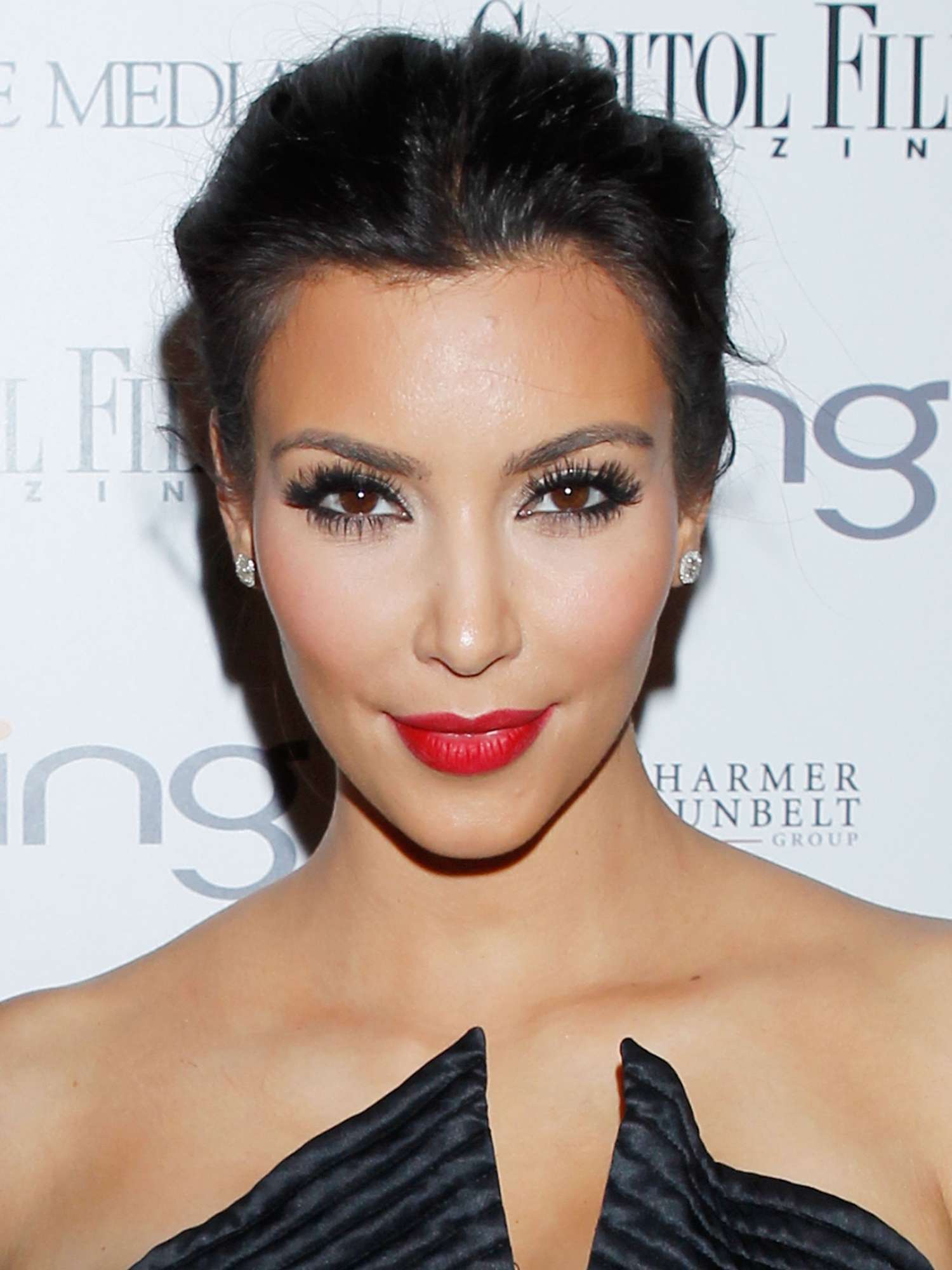 Kim Kardashian with voluminous updo, red lipstick, dramatic mascara, and blush