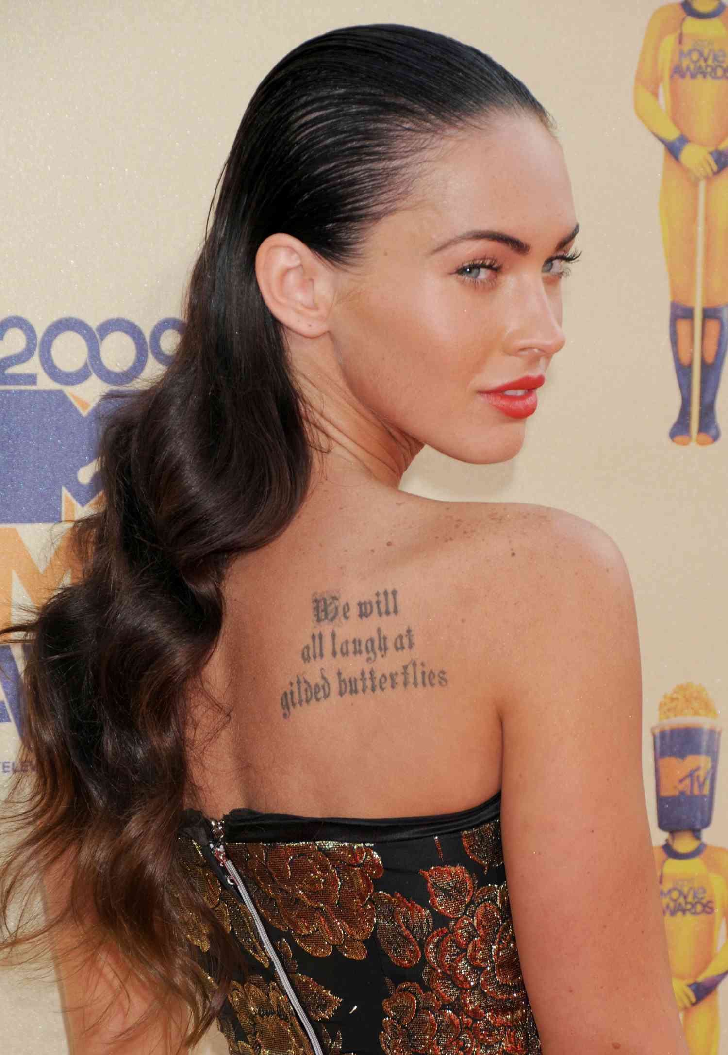 Megan Fox at the 2009 MTV Movie Awards red carpet with her hair slicked back. The top of her head is styled to appear wet and when it reaches her neck it transitions to looking dry.