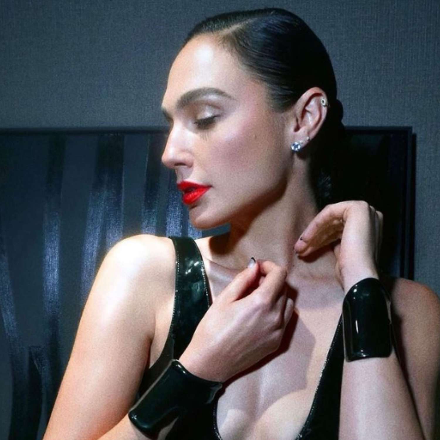 Gal Gadot with a deep side part and slicked-back ballet bun.