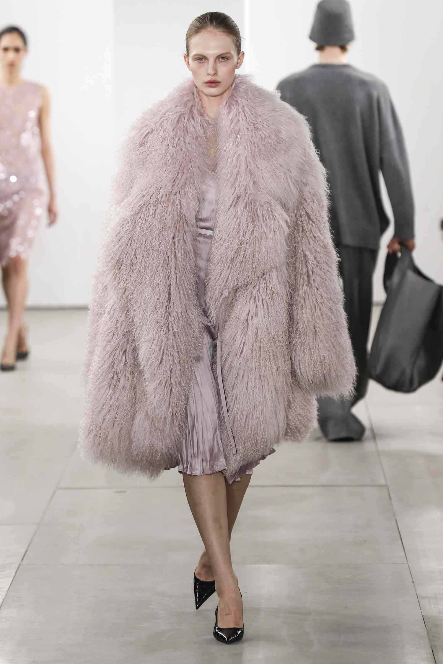 A model walks the Michael Kors runway show in an oversized pink jacket. 