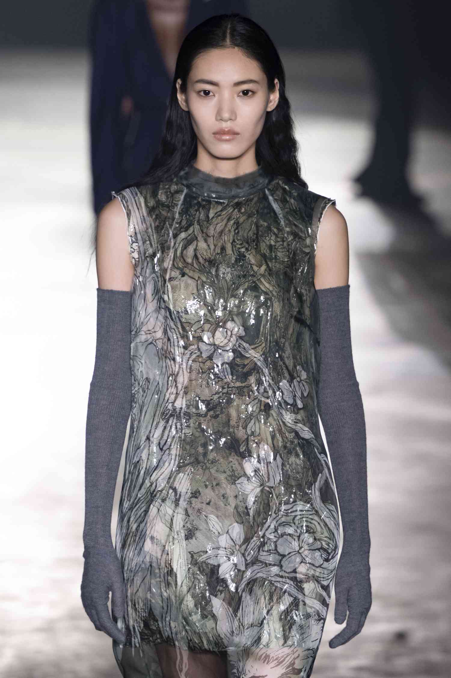 A model walking the Jason Wu runway show with natural, glowy skni and a gray pattern mini dress.