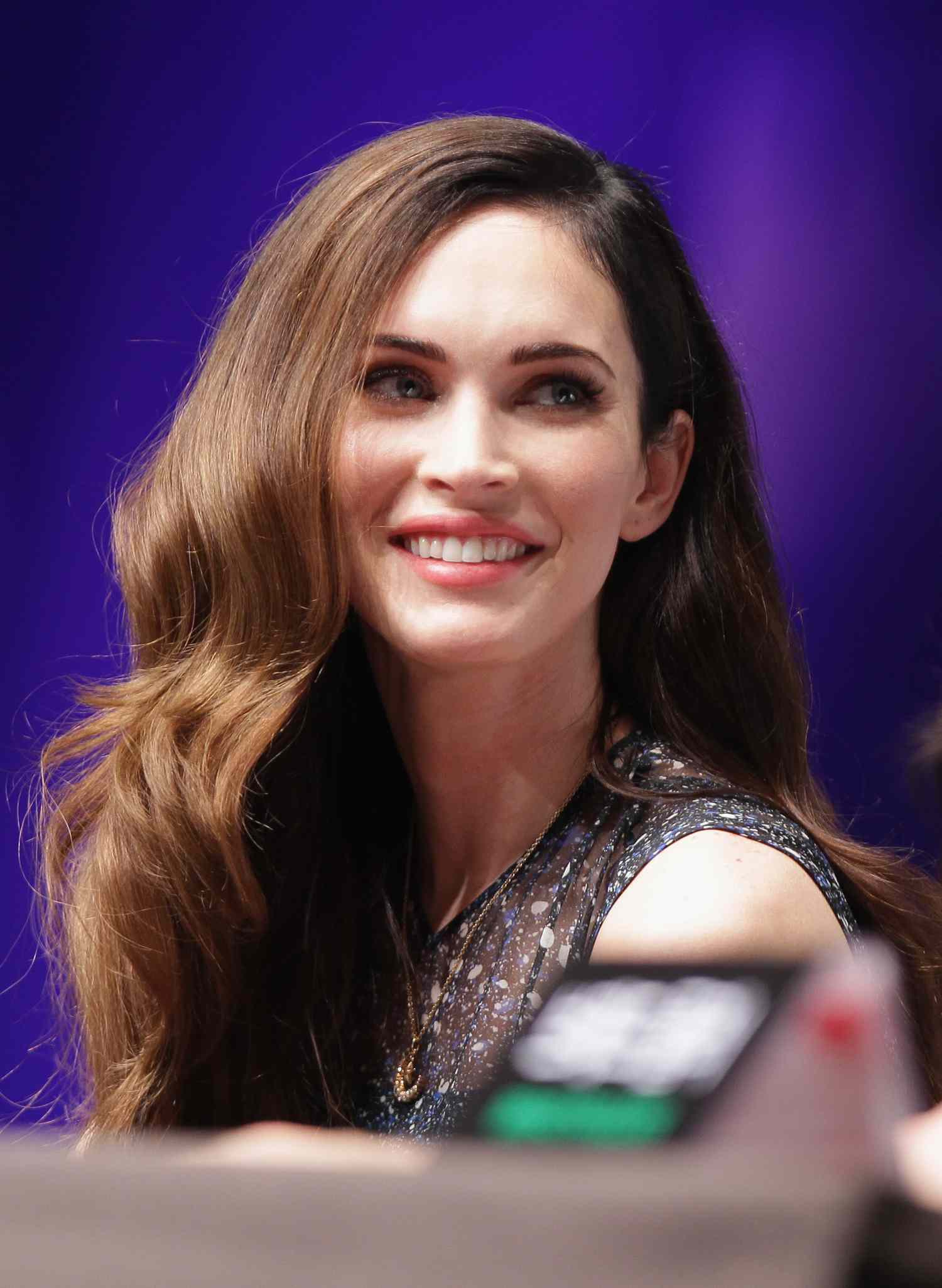 Megan Fox in South Korea with her brown hair in a voluminous side part 