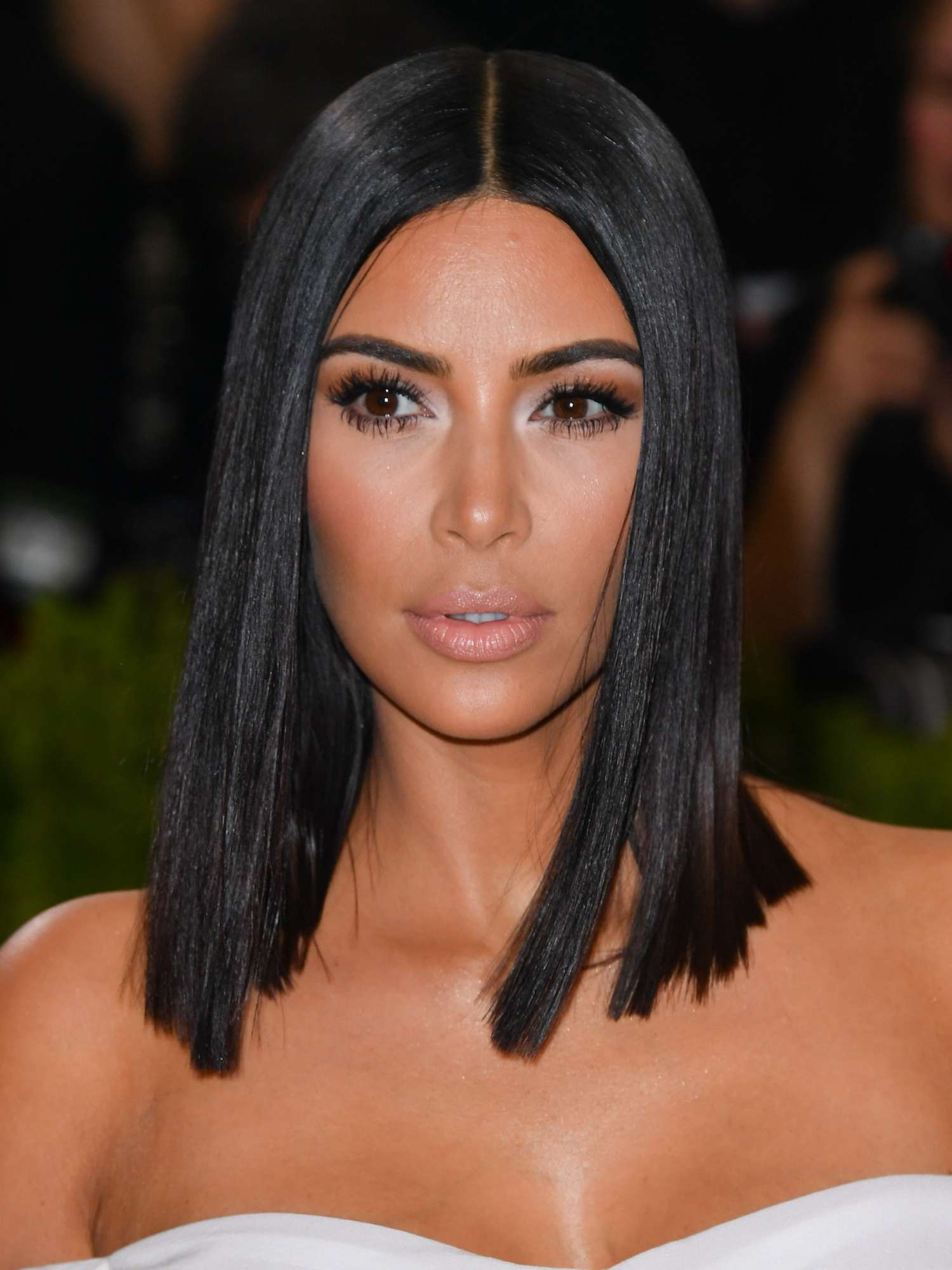 Kim Kardashian with blunt bob hairstyle with middle part, shimmer eyeshadow, mascara, and nude lip