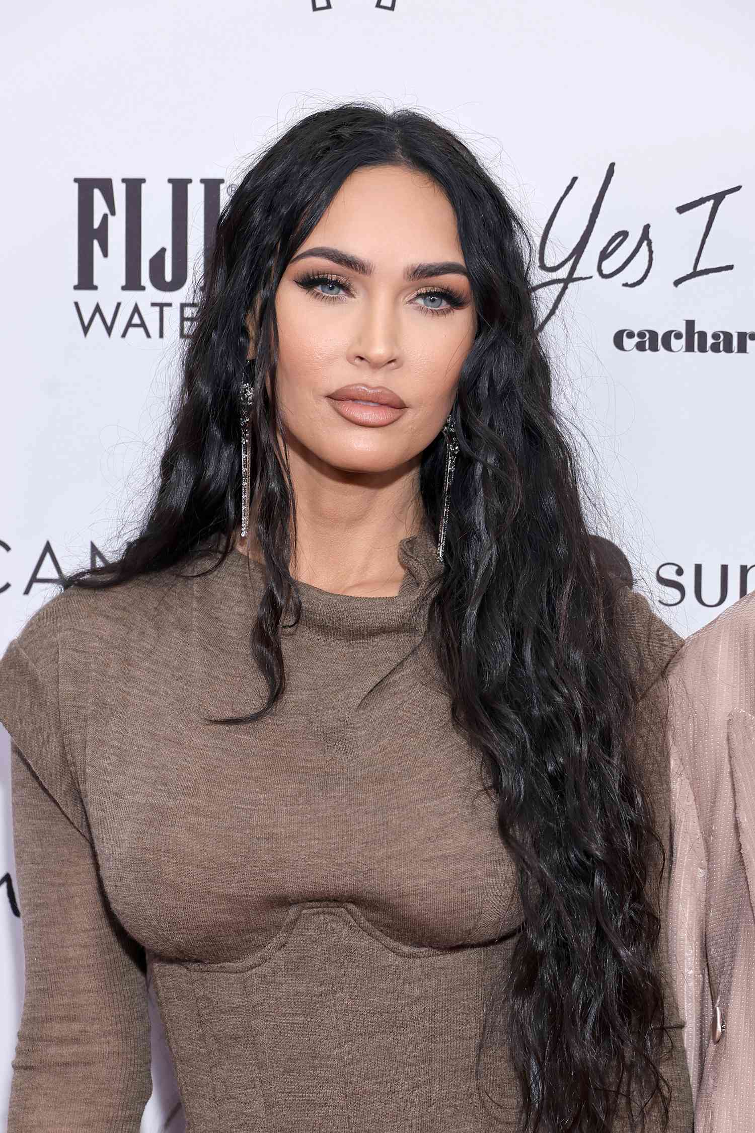 Megan Fox at The Daily Front Row's 6th Annual Fashion Awards with her black hair in a wavy middle part with a few tiny braids scattered throughout.