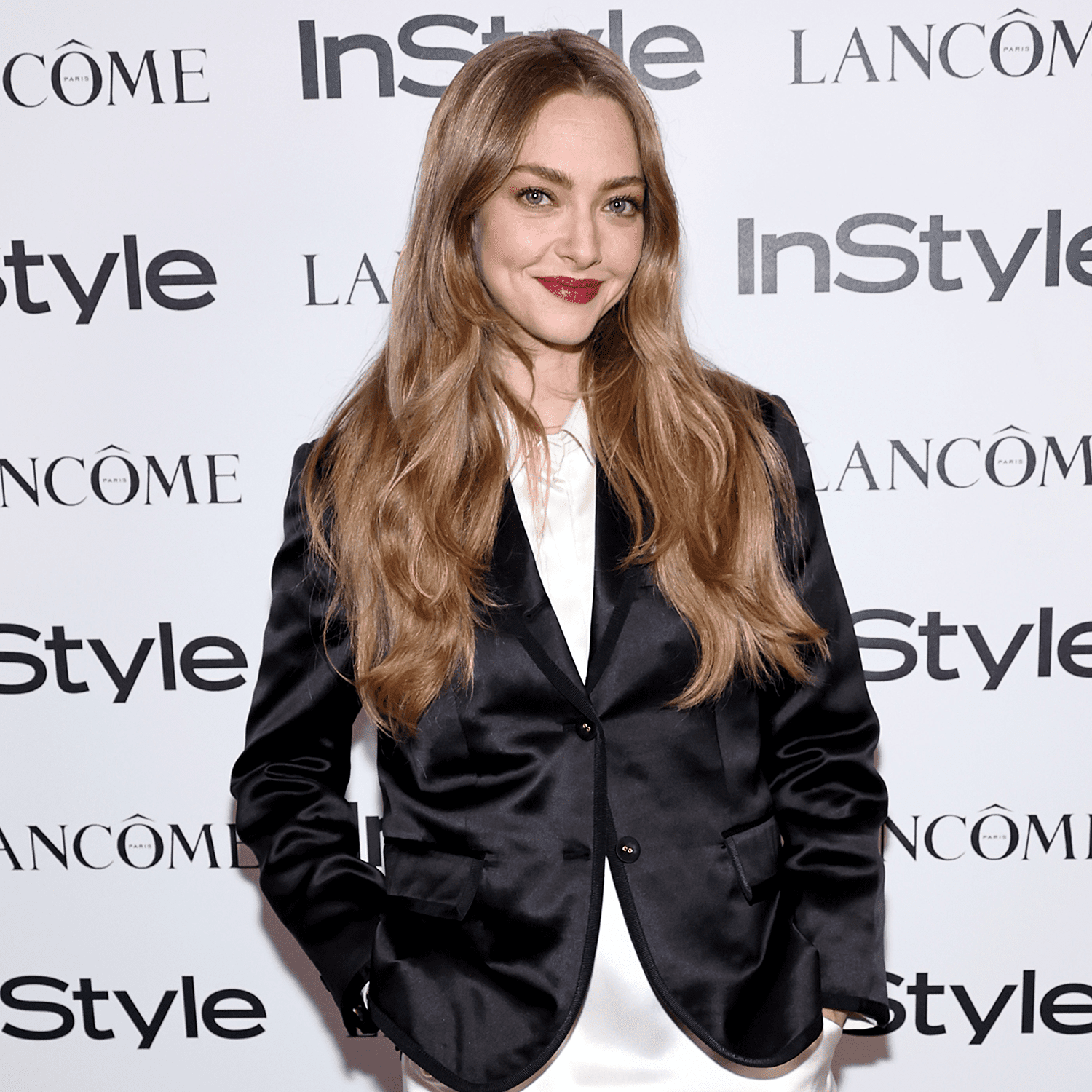 Amanda Seyfried wearing dark red lipstick and a black blazer