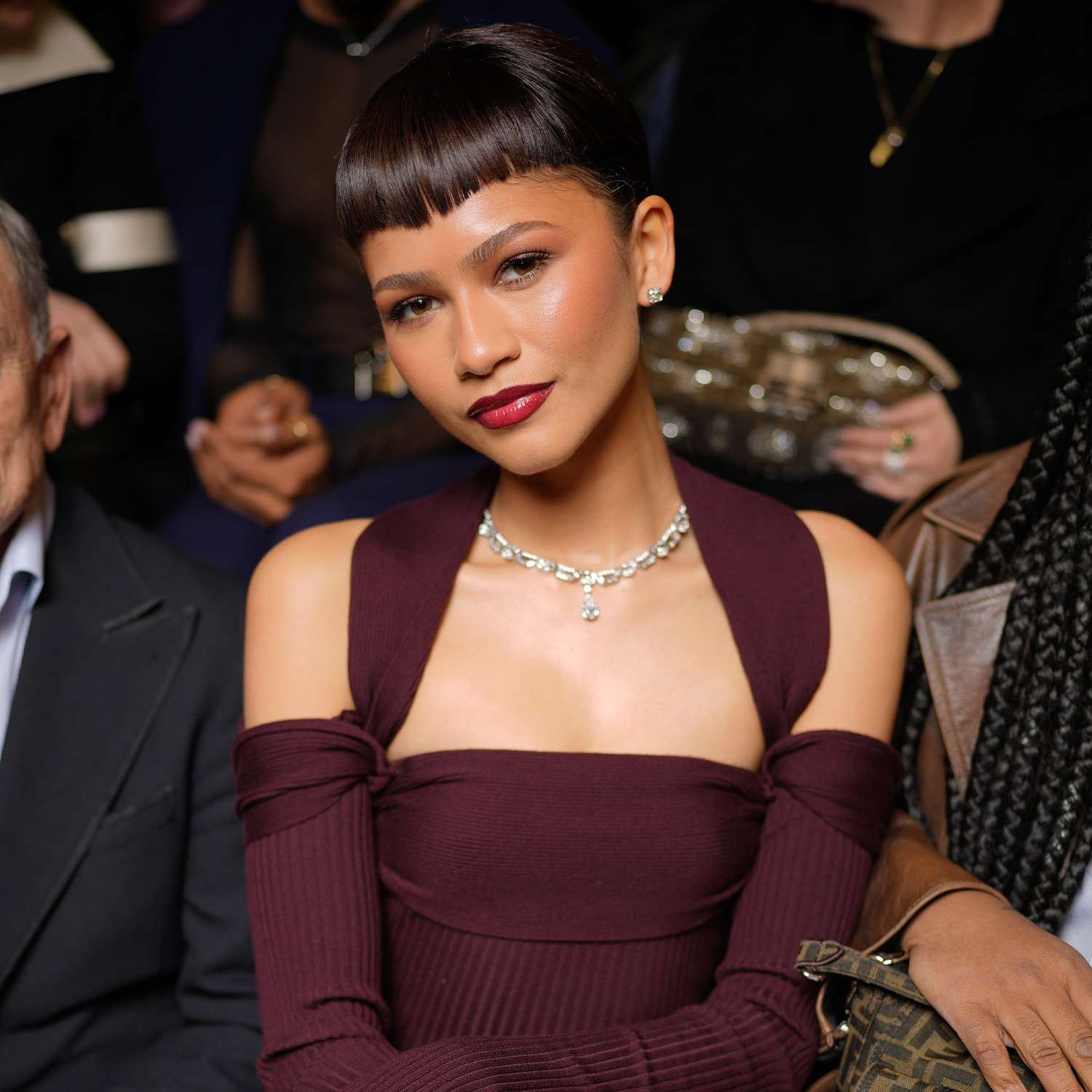 Zendaya at the Feni Haute Couture show with blunt bangs and vampy wine-red makeup and clothes