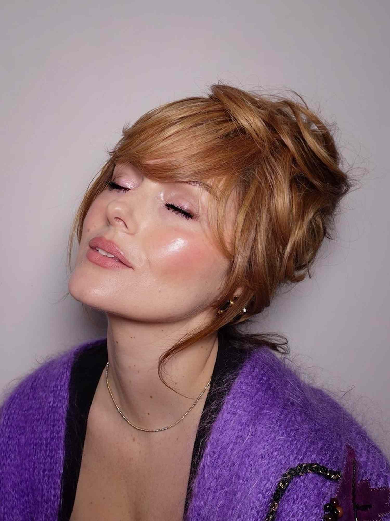 Katie Jane Hughes with a strawberry blonde updo hairstyle and radiant pink makeup look