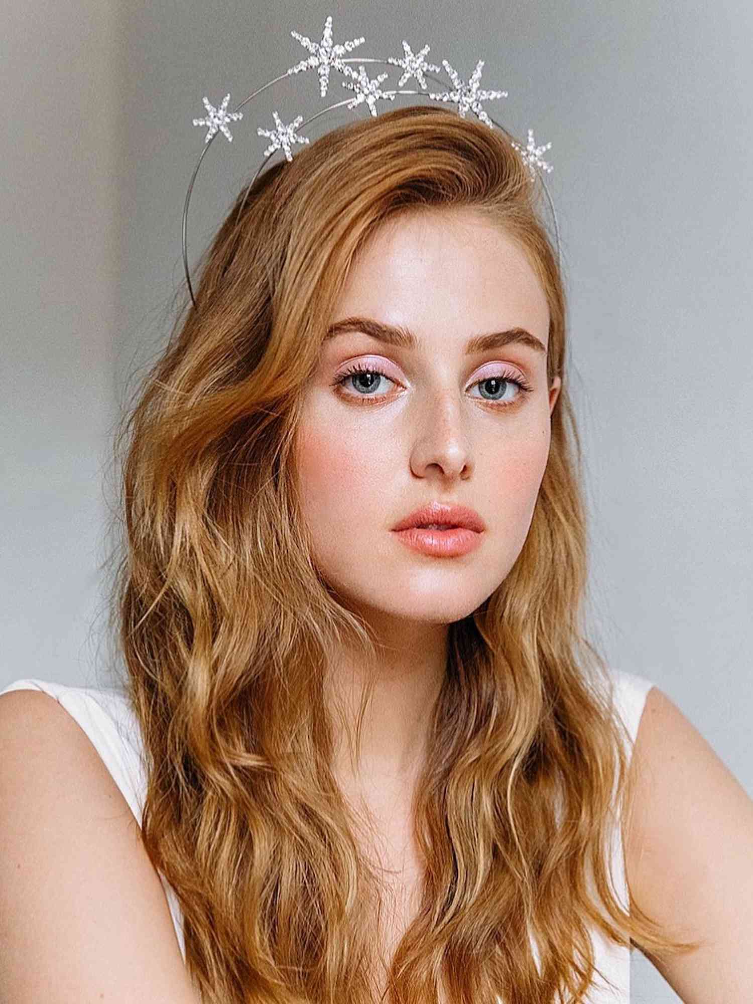 Woman with ginger hair, pink-toned makeup, and star floating headband