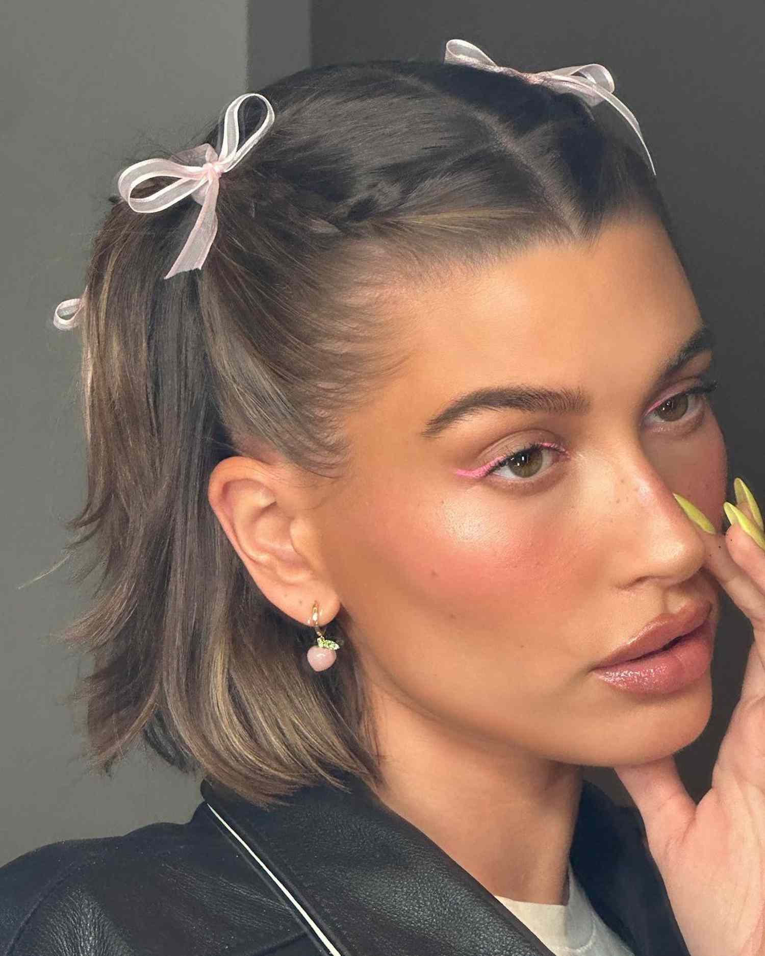 Hailey Bieber wears small French braids with bows and pink eyeliner