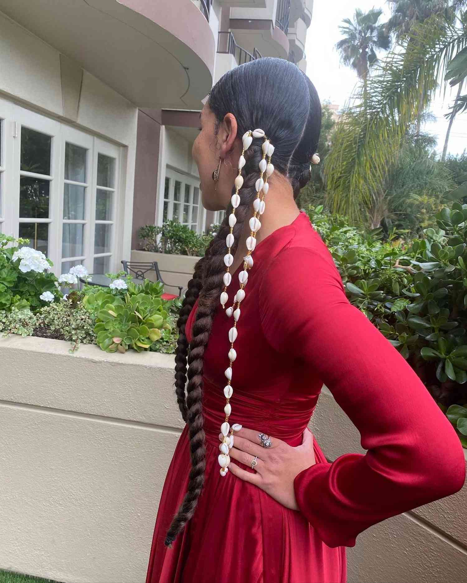 Model wears braided pigtails accessorized with shells 