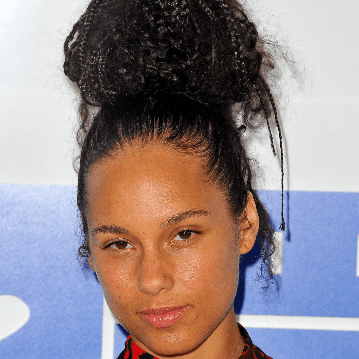 Alicia keys wearing topknot hairstyle on curly hair 