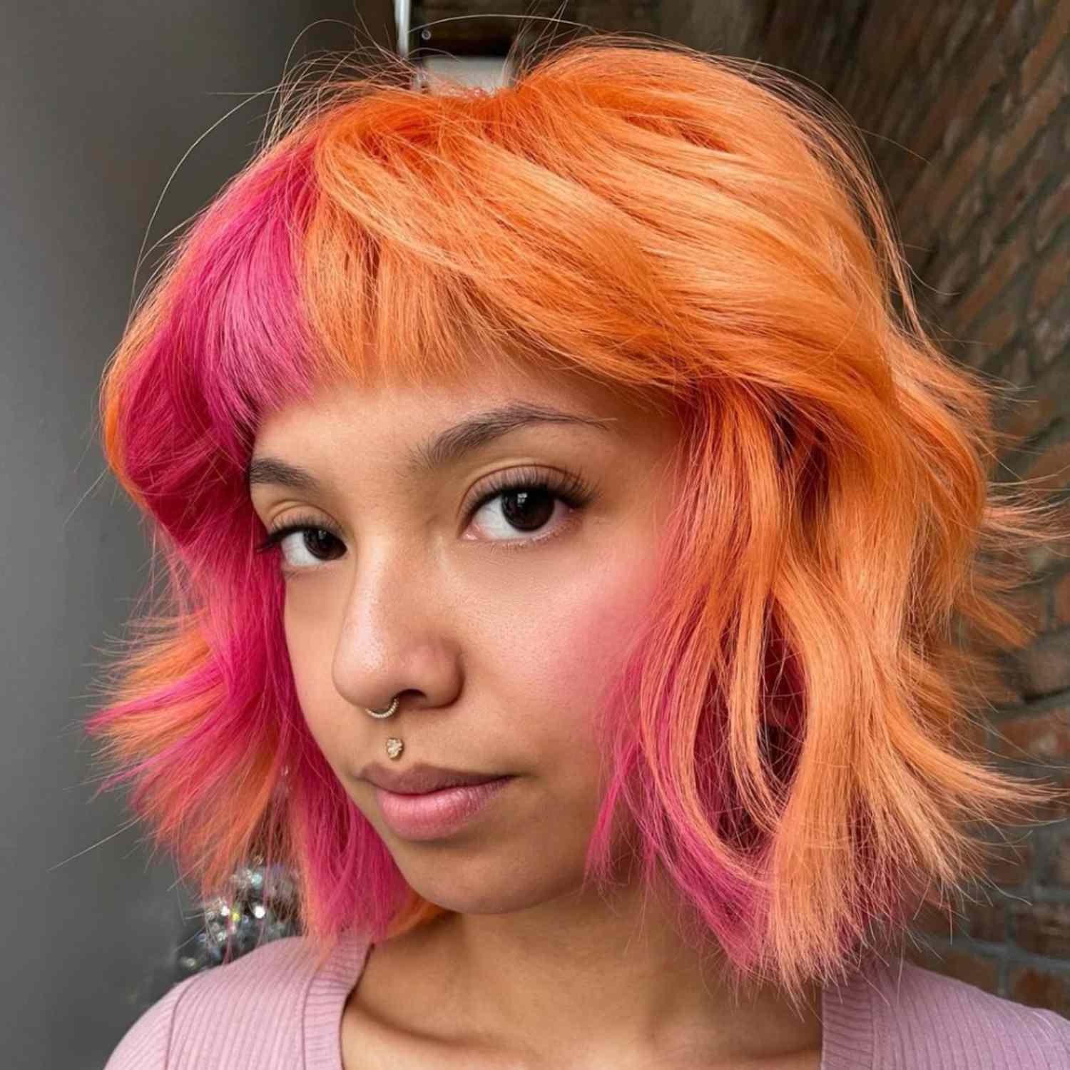 Bob with short blunt bangs, half pink, half orange.