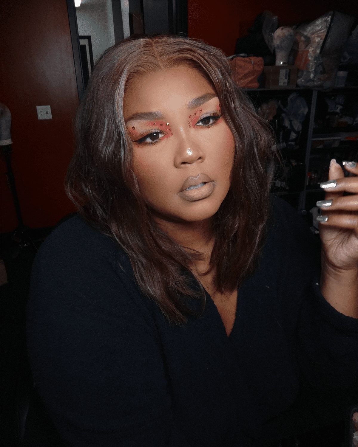 Lizzo wearing red gem makeup