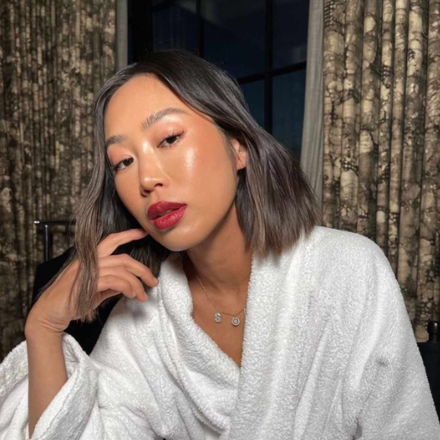 Dewy skin with a brick red lip.