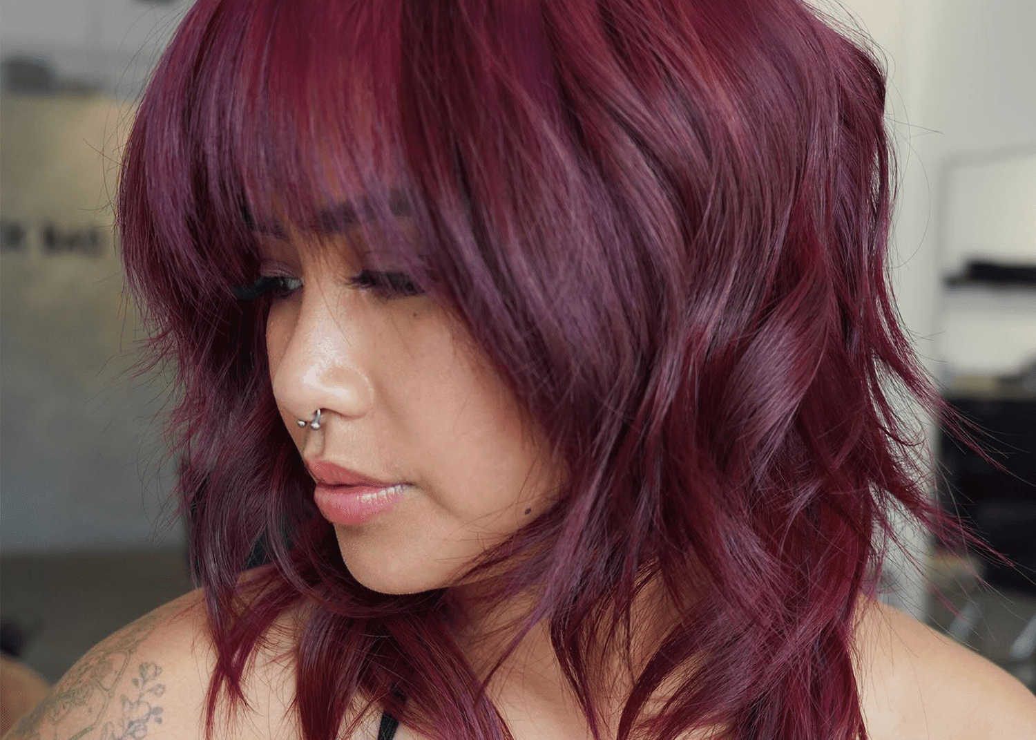 woman with a maroon lob with her head turned to the side