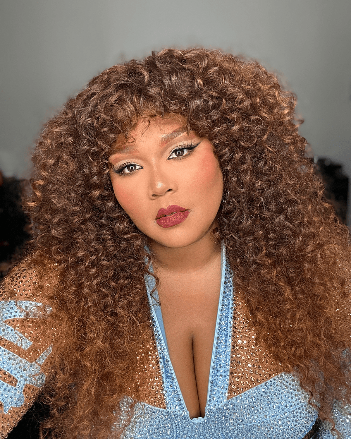 Lizzo wearing brown eyeshadow and red lisptick