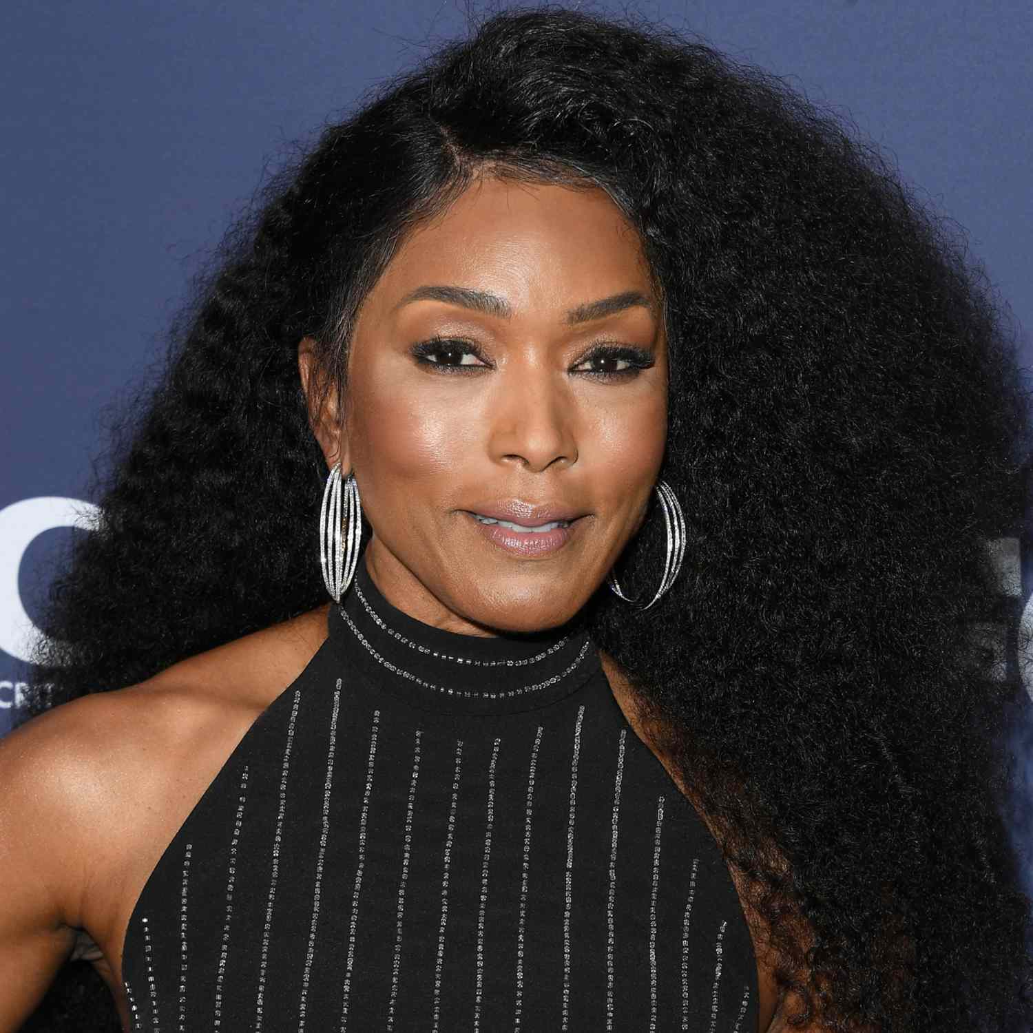 Angela Bassett with her fluffy, coily hair deep side parted