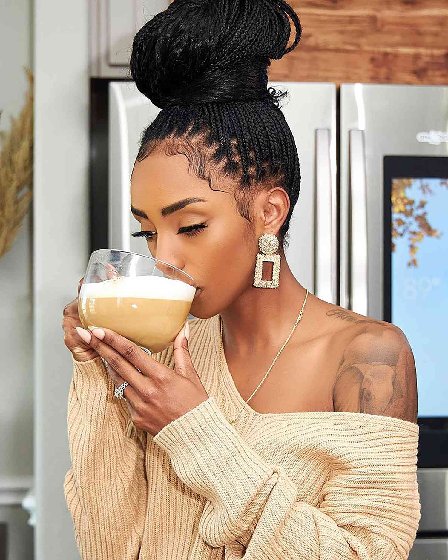 Woman drinking coffee, her hair in a box braids top knot