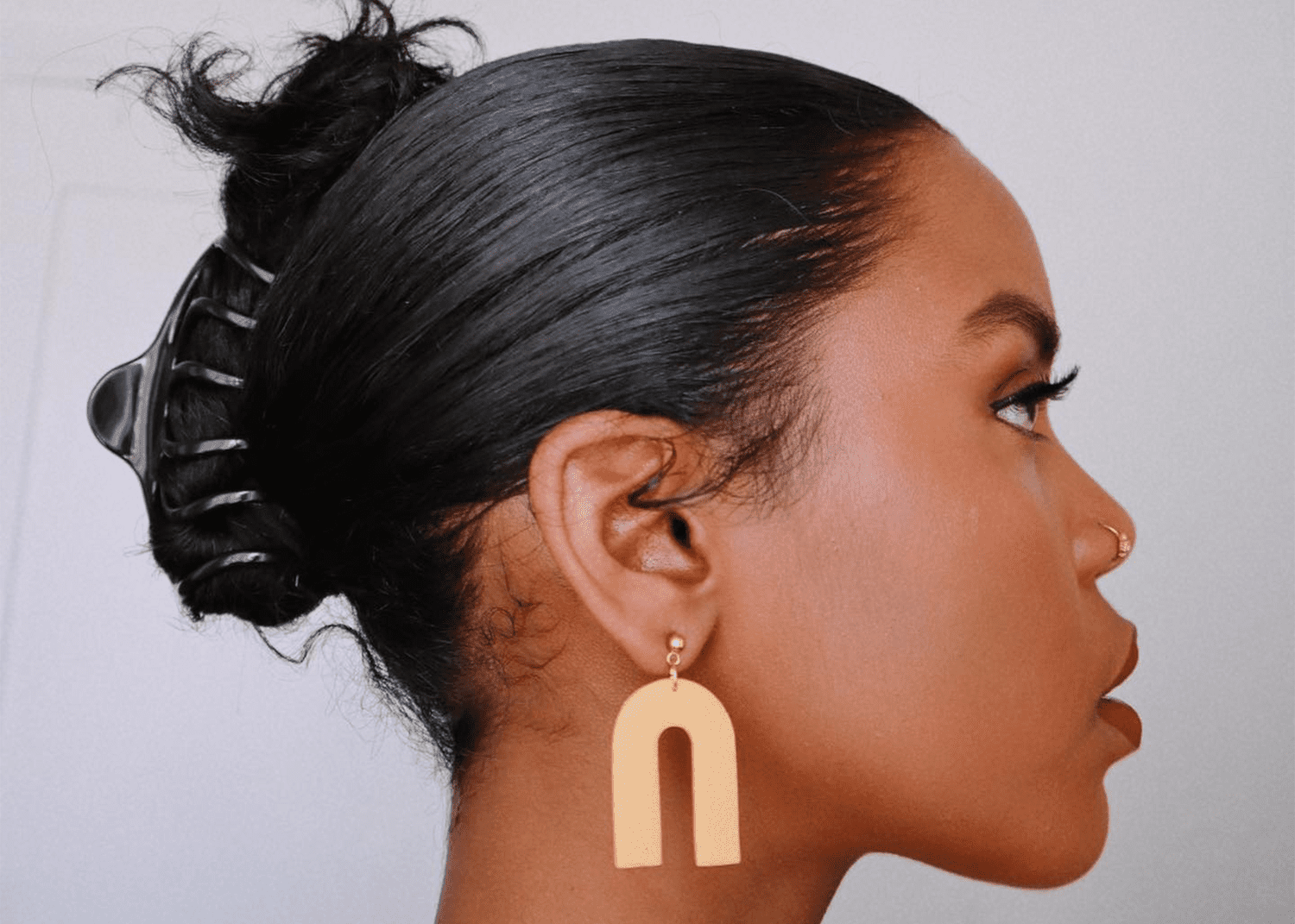 Woman turned to the side with her hair in a claw clip and chunky earrings