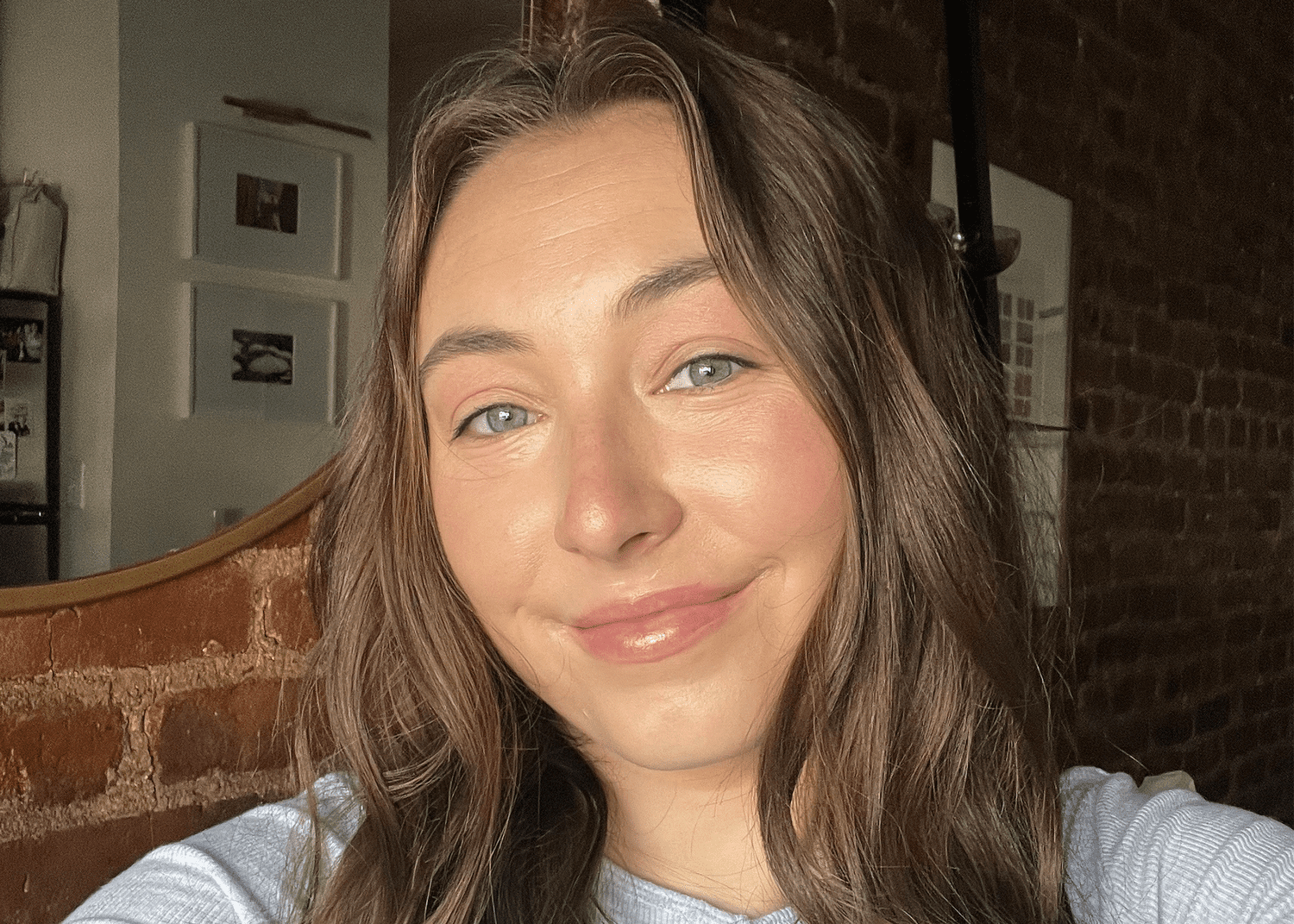 Selfie of a woman with long brown hair in a light grey shirt