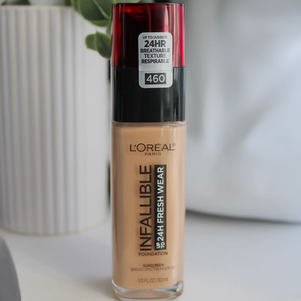 L'Oreal Paris Infallible Fresh Wear Foundation bottle with white objects and plants in background