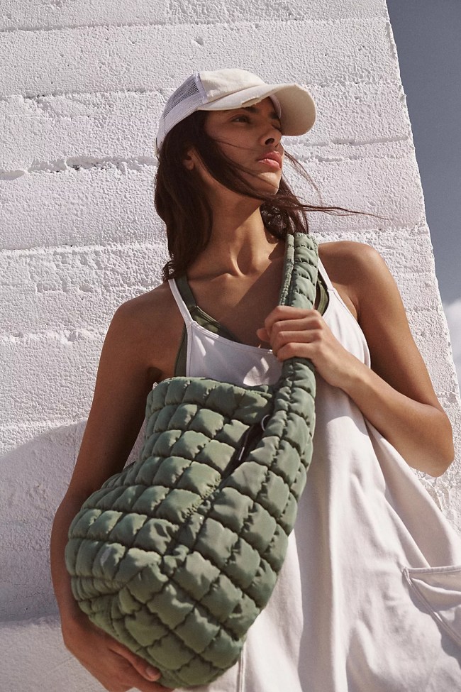 A woman holding a green quilted bag