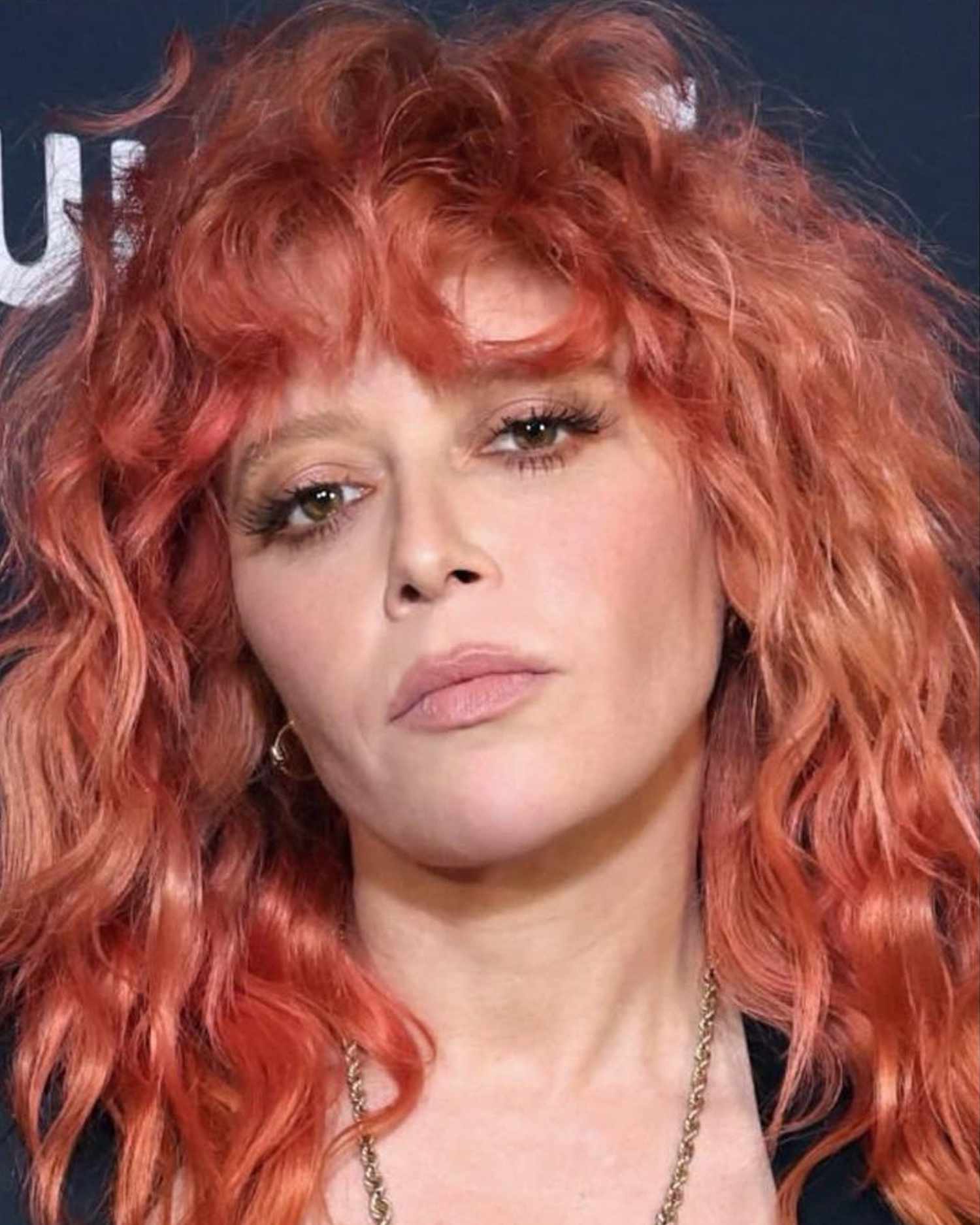 Natasha Lyonne with rose gold curly hair and soft metallic taupe eye makeup