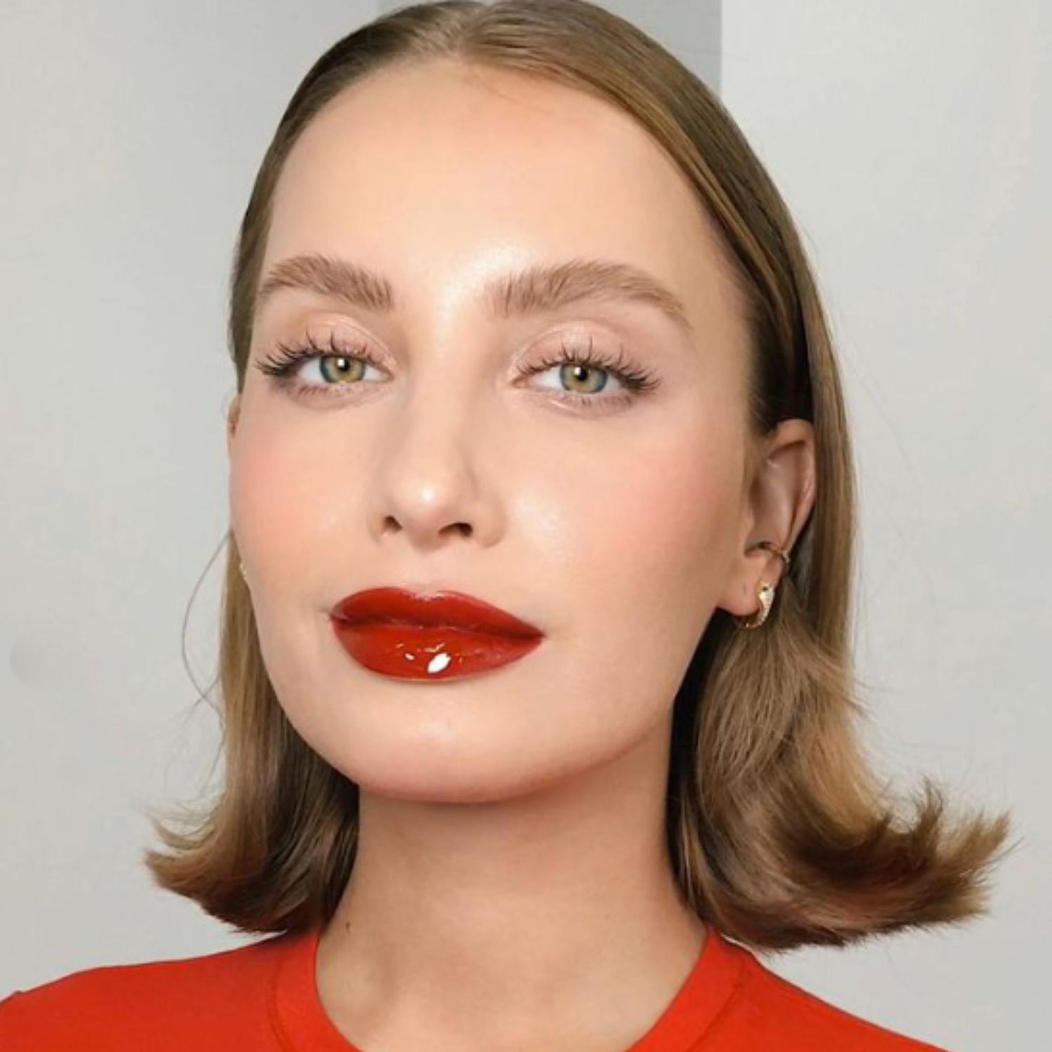 Vinyl dark red lipstick with clean, glowy skin and groomed brows.